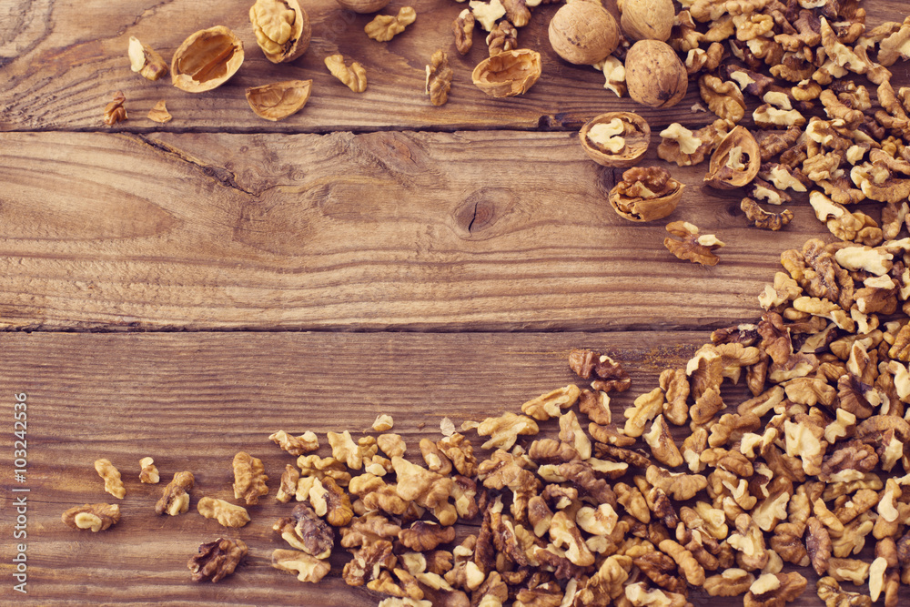 Walnut kernels and whole walnuts on rustic old wooden table Walnut kernels and whole walnuts on rustic old wooden table