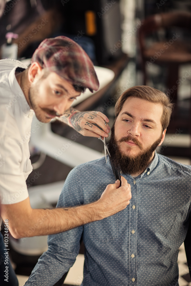 Obraz premium Hairdresser shaving with scissors and combs.