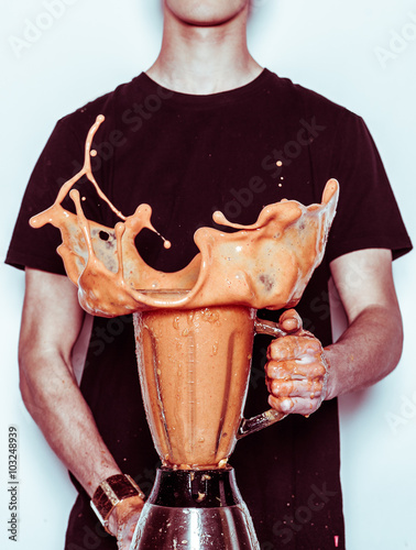 Man holding splashing blender photo