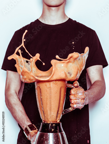 Man holding splashing blender