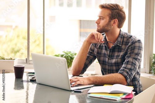Young entrepreneur looking out the window in thought