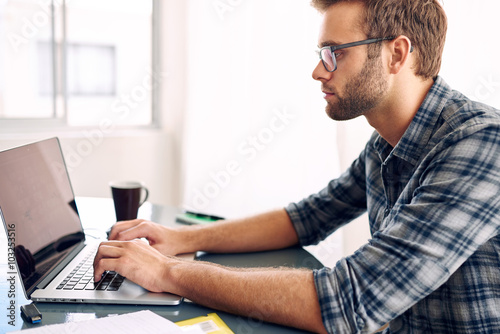 Side shot of a businessman working on his laptop