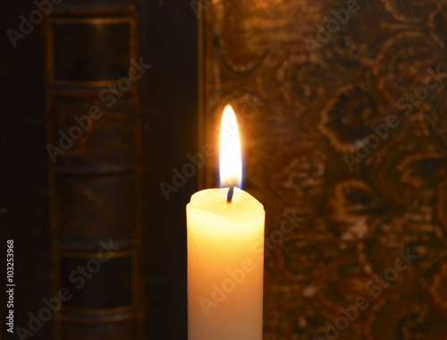 burning candle and antique book background