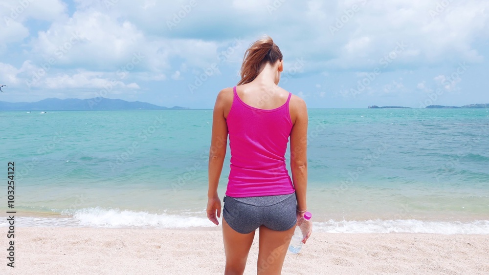 Fitness sport woman doing sporty exercise on beach outside at sunset. Healthy lifestyle image of beautiful young asian woman jogging on black sand beach. Fitness sport woman doing sporty exercise on beach outside at sunset. Healthy lifestyle image of beautiful young asian woman jogging on black sand beach.
