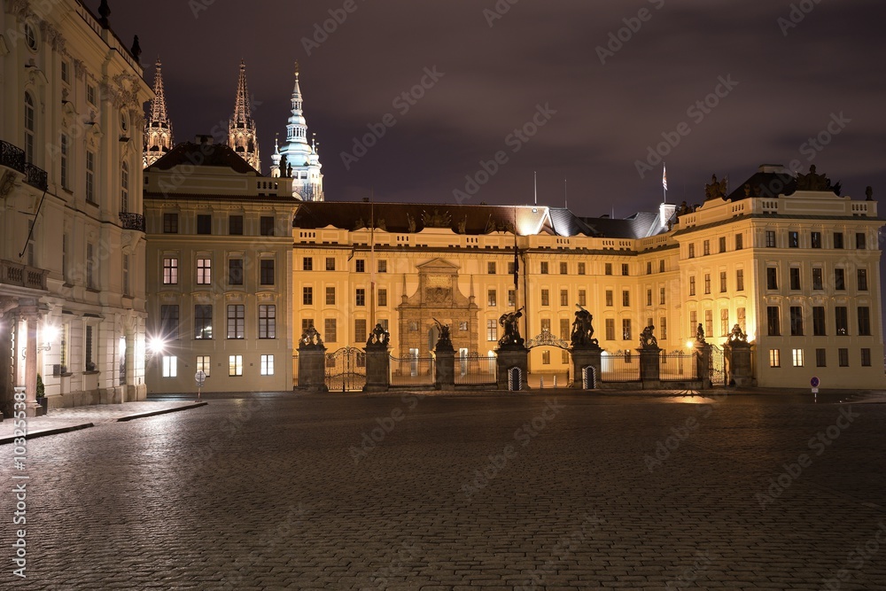 Night Picture of the main entrance to the Prague castle in Prague in Czech Republic. Gate of giants, with baroque statues on the top of pilots. Buildings of the caste are residence of czech president.