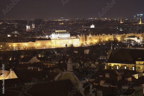 Night panoramatic view on the city centre of the Prague, capitol of the Czech republic taken from Prague castle. Old city roofs and nathional theatre caled golden chapel on the bank of Vltava river. photo