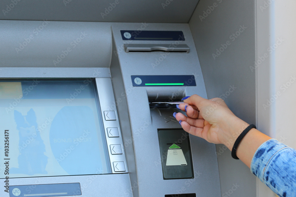 woman hand inserting credit card to ATM