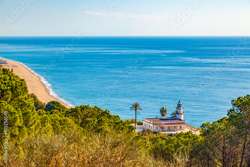 The famous lighthouse near Calella, Spain, overlooking the blue Mediterranean Sea. photo