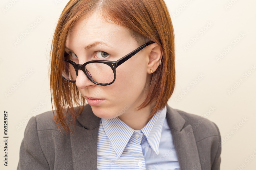 Beautiful business woman with red hair and blue eyes wearing glasses.