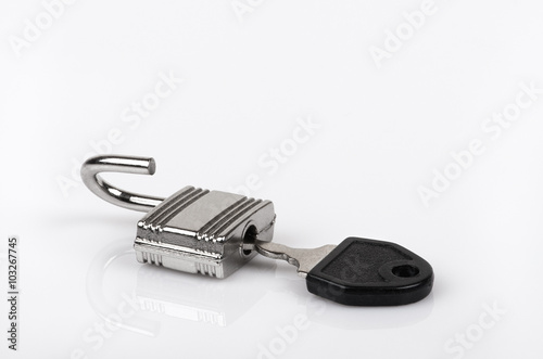 an opened padlock with inserted key, closeup white isolated