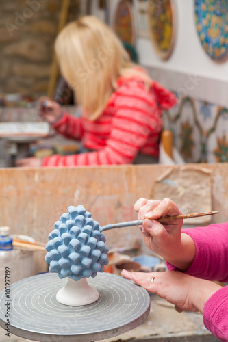 A pottery decorator painting a typical ceramic pine cone in his work table in Caltagirone, Sicily