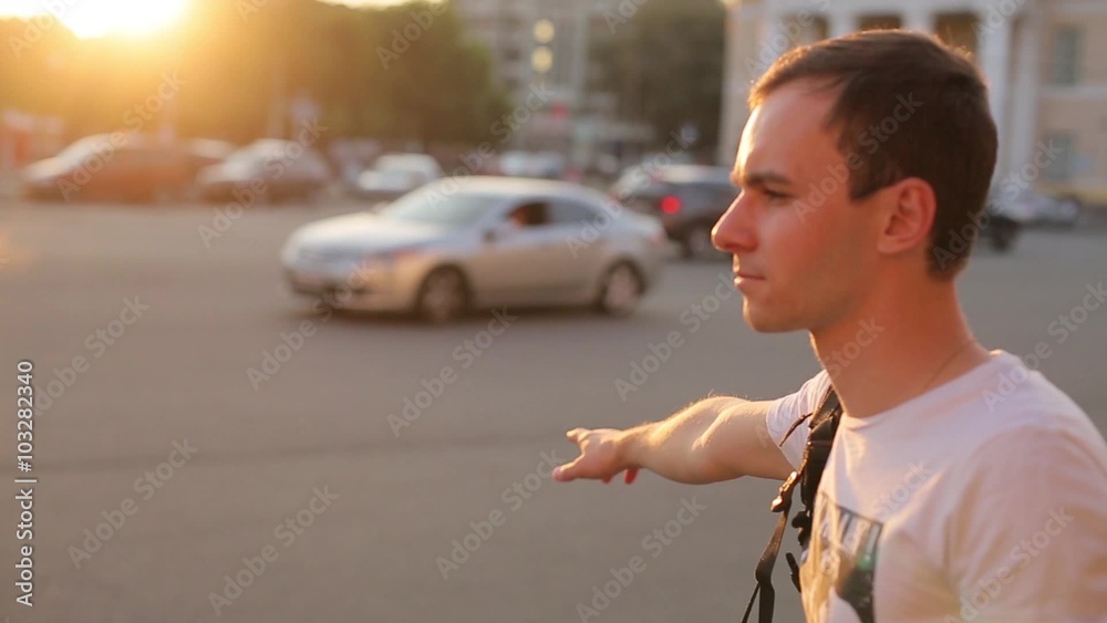 A guy stops the car on the street in summer. A guy stops the car on the street in summer.
