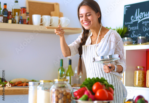 Cooking woman in kitchen with wooden spoon