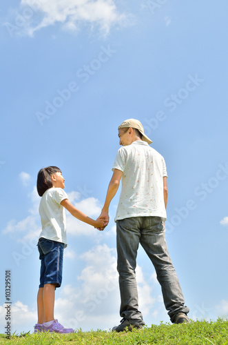 青空で手をつなぐ親子 夏 後姿 Stock 写真 Adobe Stock