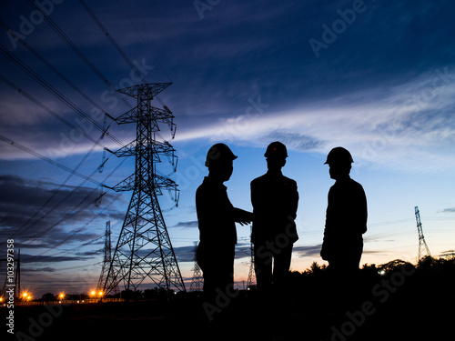 Fototapet silhouette man of engineers standing at electricity station over