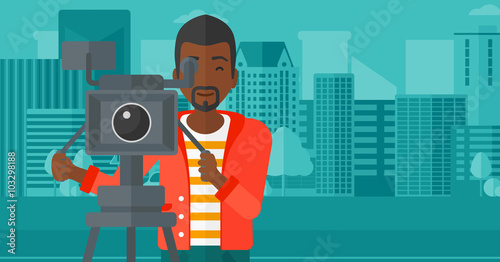 Cameraman with movie camera on a tripod.