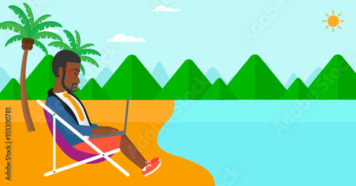 Businessman sitting in chaise lounge with laptop.