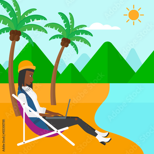 Business woman sitting in chaise lounge with laptop.