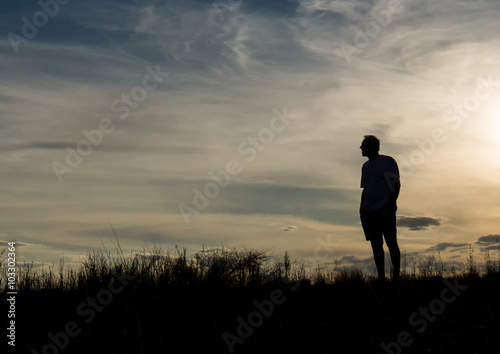 Canvas Print Man in silhouette standing on hill contemplating life and enjoying the view