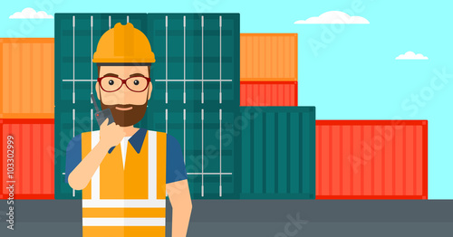 Stevedore standing on cargo containers background.