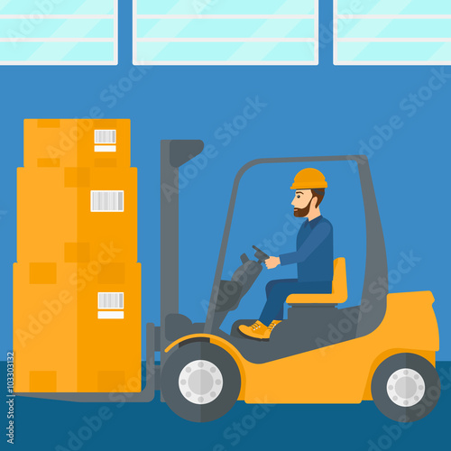 Warehouse worker moving load by forklift truck.