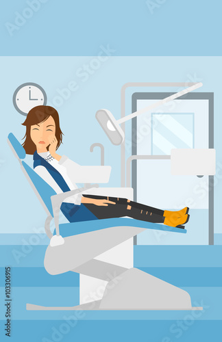 Woman suffering in dental chair.