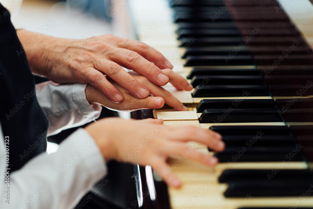 Fototapeta premium experienced hand of old music teacher helps child pupil