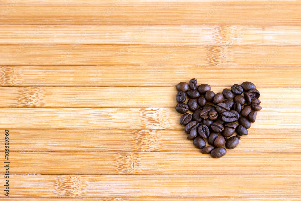 Heart shape made from coffee beans on wooden surface Heart shape made from coffee beans on wooden surface