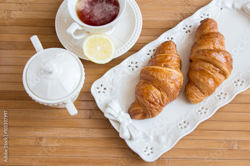 Tea and croissants at wooden table