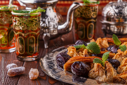 Moroccan mint tea in the traditional glasses with sweets.