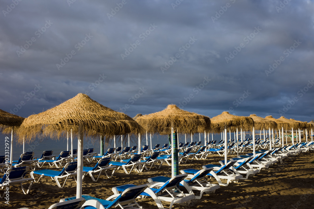 Sun Loungers on a Beach with Stormy Sky