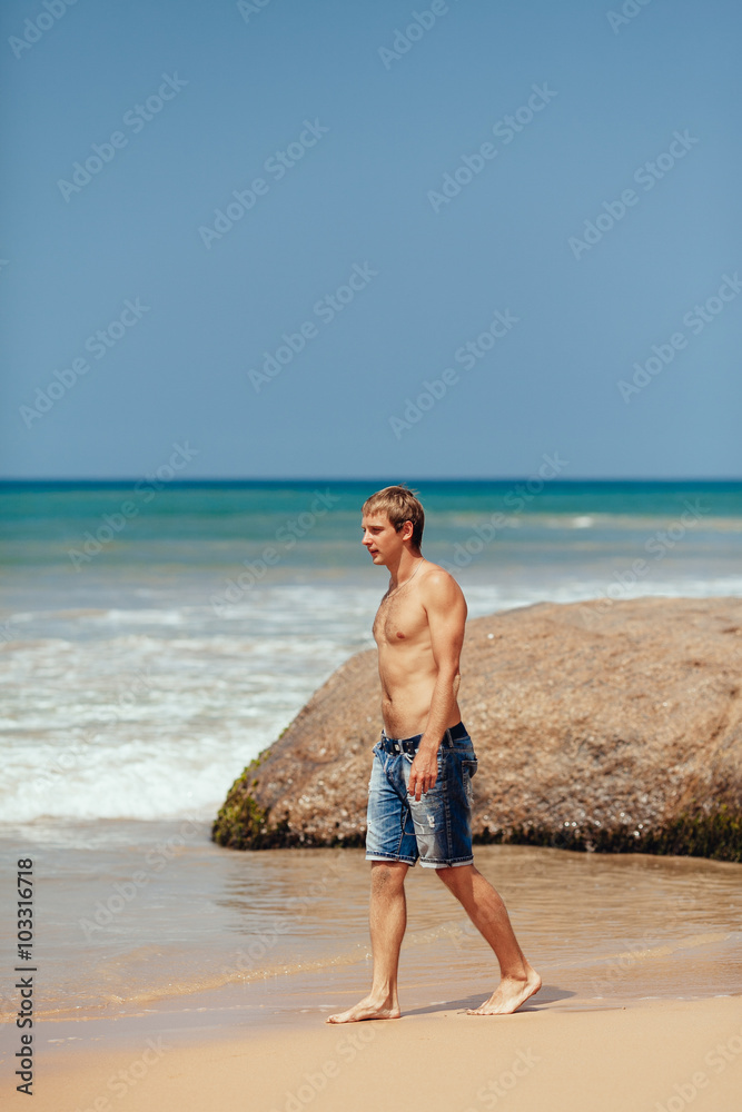 handsome man walking on the tropical beach