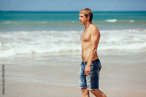 handsome man walking on the tropical beach