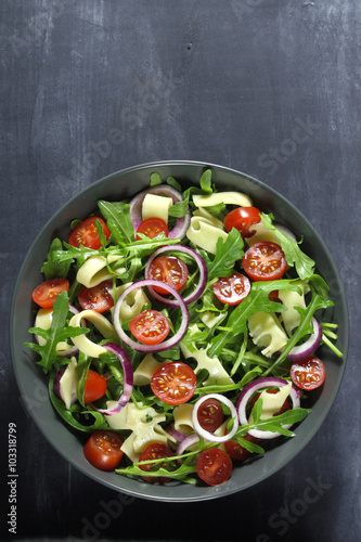 Salad with arugula, cheese, tomato and red onion