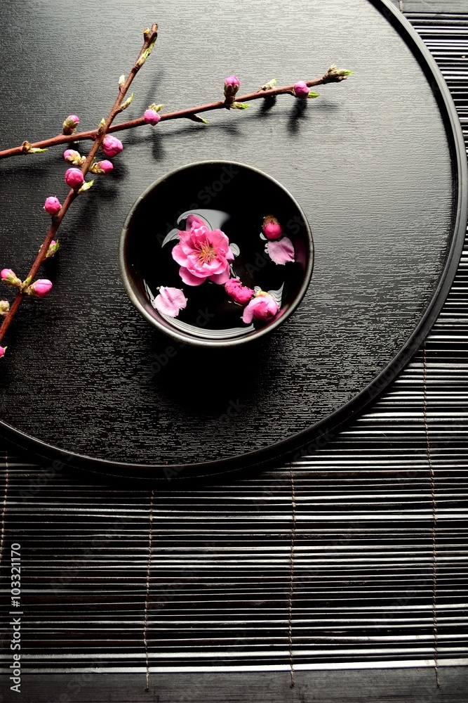 黒いおぼんの上の小鉢に浮かせた桃の花 Stock Photo Adobe Stock