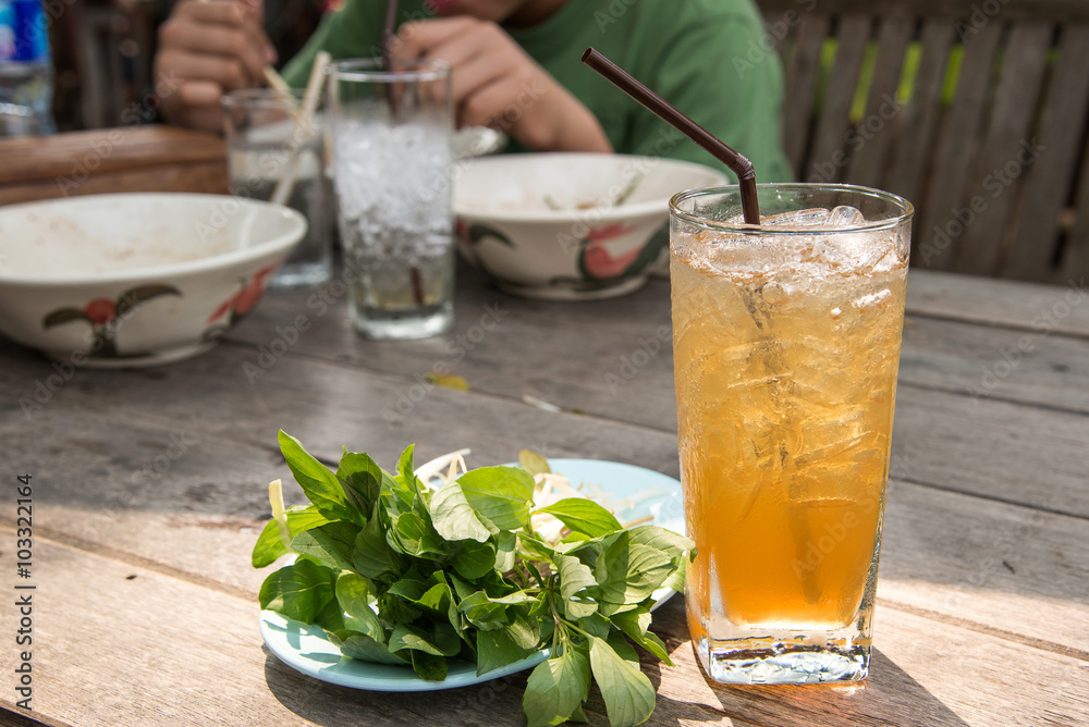 Glass tamarind juice with ice on wooden table Glass tamarind juice with ice on wooden table