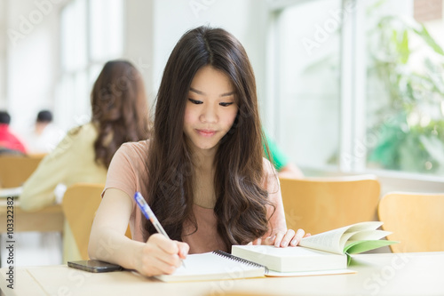 Asian student studying in the library.