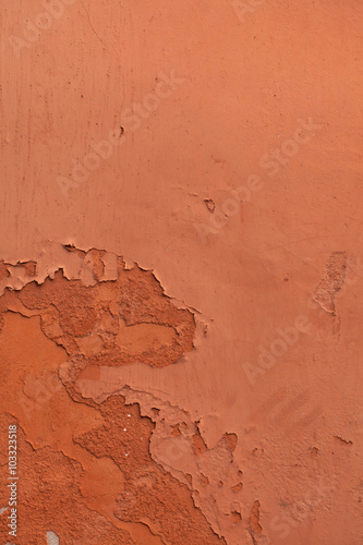 Old terracotta painted stucco wall with chipped paint. Backgroun
