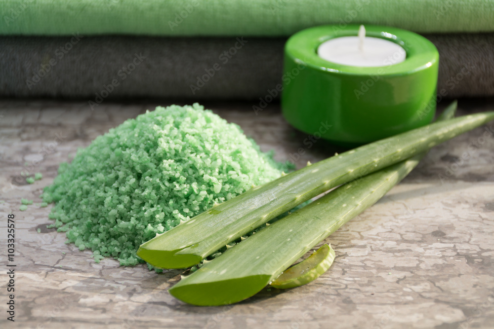 Green fresh leaves of aloe vera, green-blue candles and towels, skin treatment and rejuvenating with aloe bath salt Green fresh leaves of aloe vera, green-blue candles and towels, skin treatment and rejuvenating with aloe bath salt