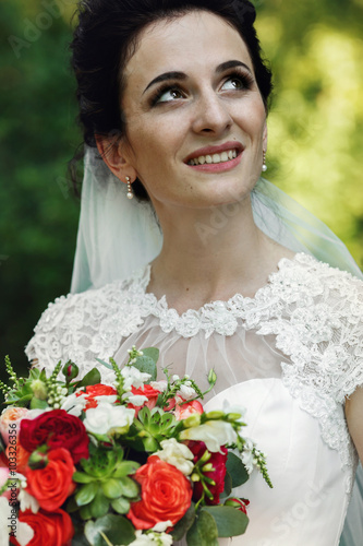 Beautiful innocent brunnete bride posing with wedding bouquet cl photo