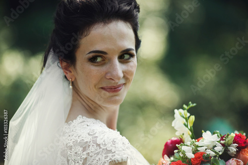 Beautiful innocent brunnete bride posing with wedding bouquet cl photo