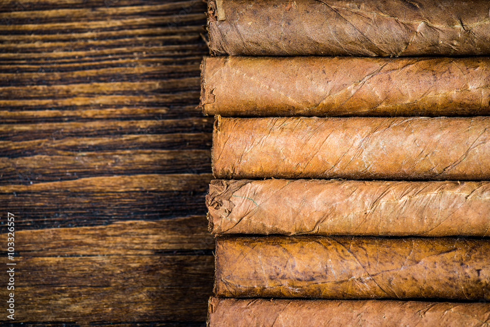 Hand rolled cigars on wooden table Hand rolled cigars on wooden table