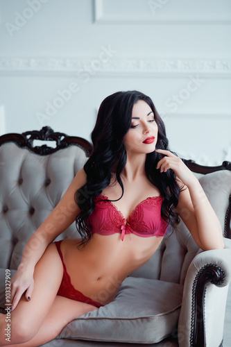 Perfect, sexy body, legs and ass of young woman wearing seductive lingerie. Sensual girl posing on sofa in erotical way