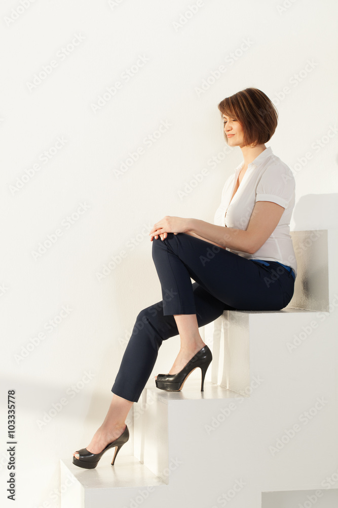 Fototapeta premium Relaxed businesswoman sitting on stairs with eyes closed
