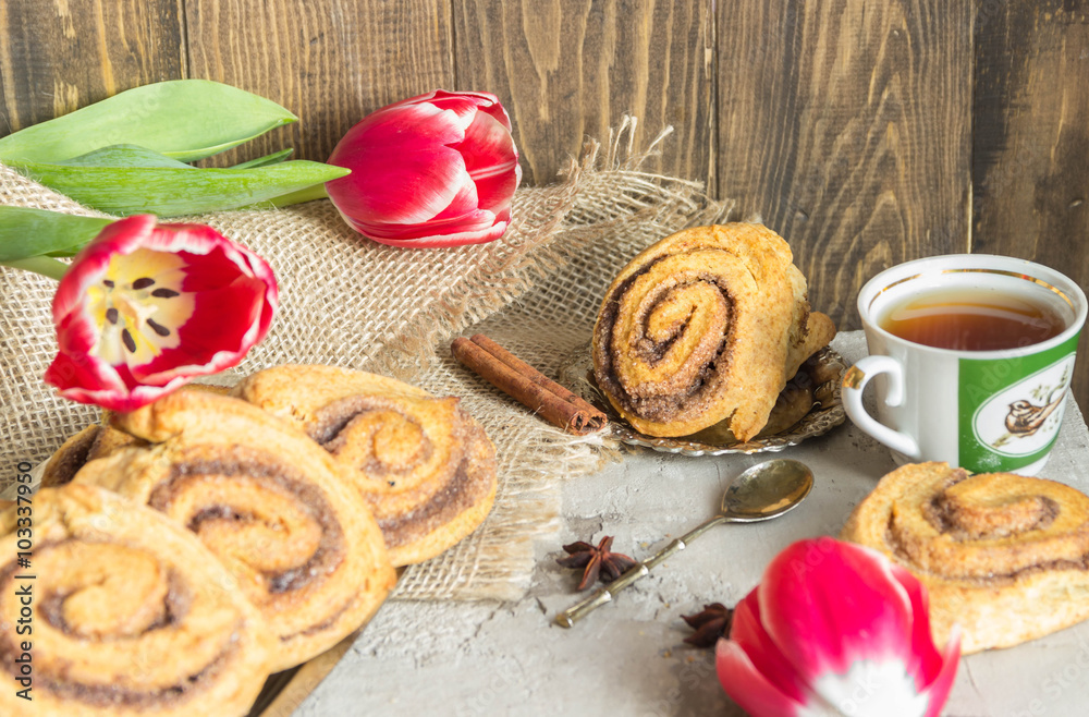 Rolls puff pastry with cinnamon and sugar, tea Cup,flowers