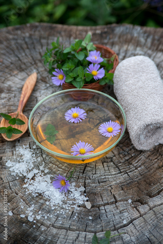 Spa and wellness setting with sea salt, oil essence, flowers and photo