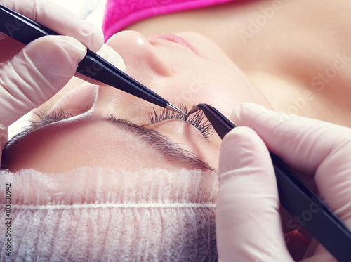 young beautiful girl is getting eyelash extentions closeup