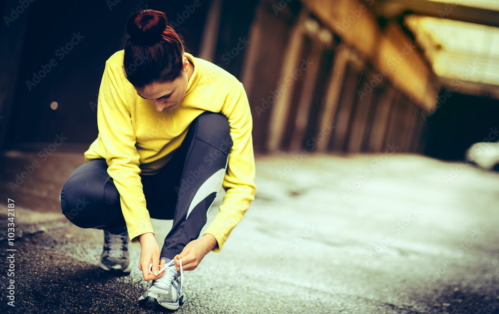 young woman preparing for a run/tied shoelace young woman preparing for a run/tied shoelace