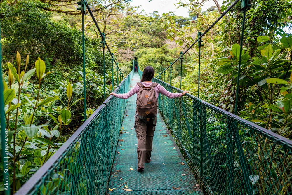 Fototapeta premium Girl on hanging bridge in cloudforest - Monteverde, Costa Rica