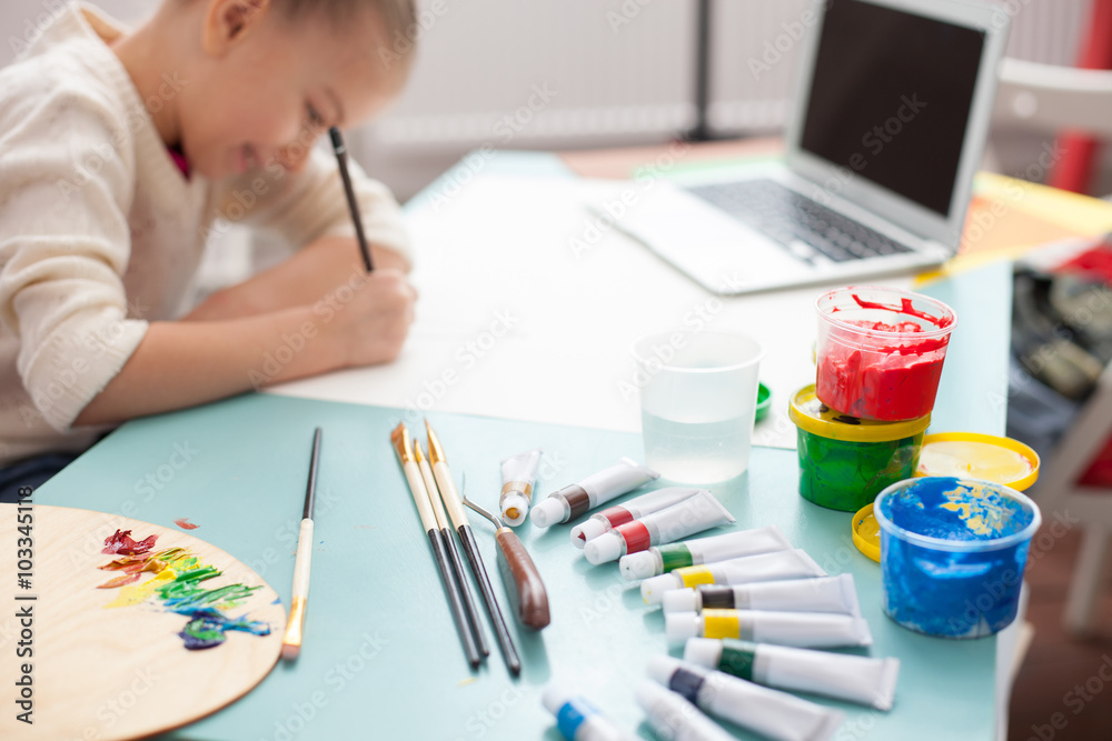 Cheerful female child is painting at home Cheerful female child is painting at home